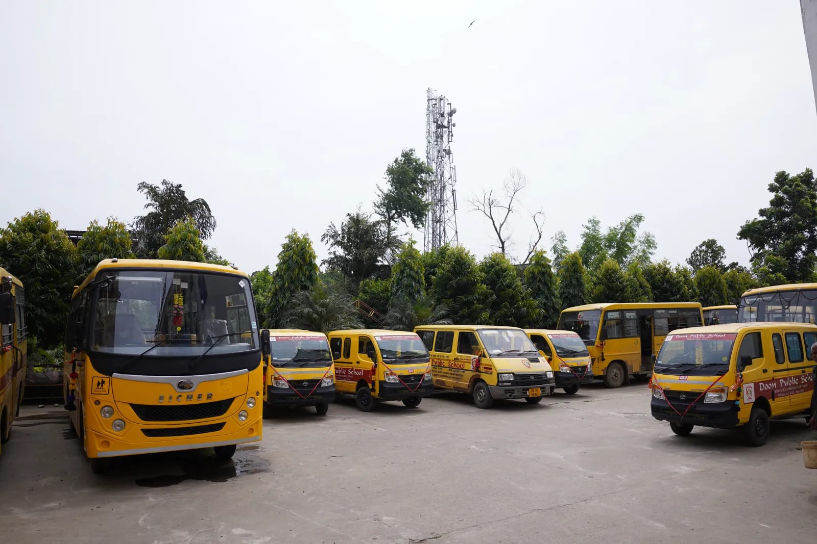 The Doon Public School fleet of yellow buses and vans parked on campus